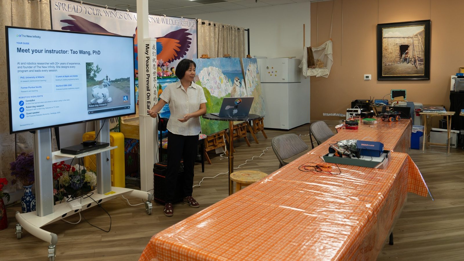 Dr. Wang introduces herself at the October 25 info session, with robot hardware laid out on the table